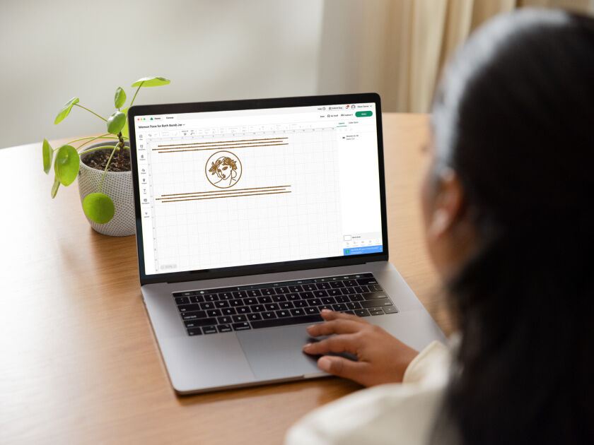 Woman's hands feeding material into Cricut Joy Xtra