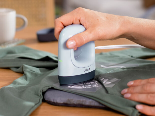 La Cricut EasyPress Mini&trade; LT est utilis&eacute;e sur un t-shirt vert.
